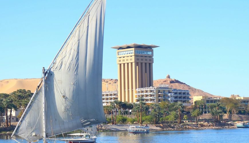 white sail boat on water near city buildings during daytime